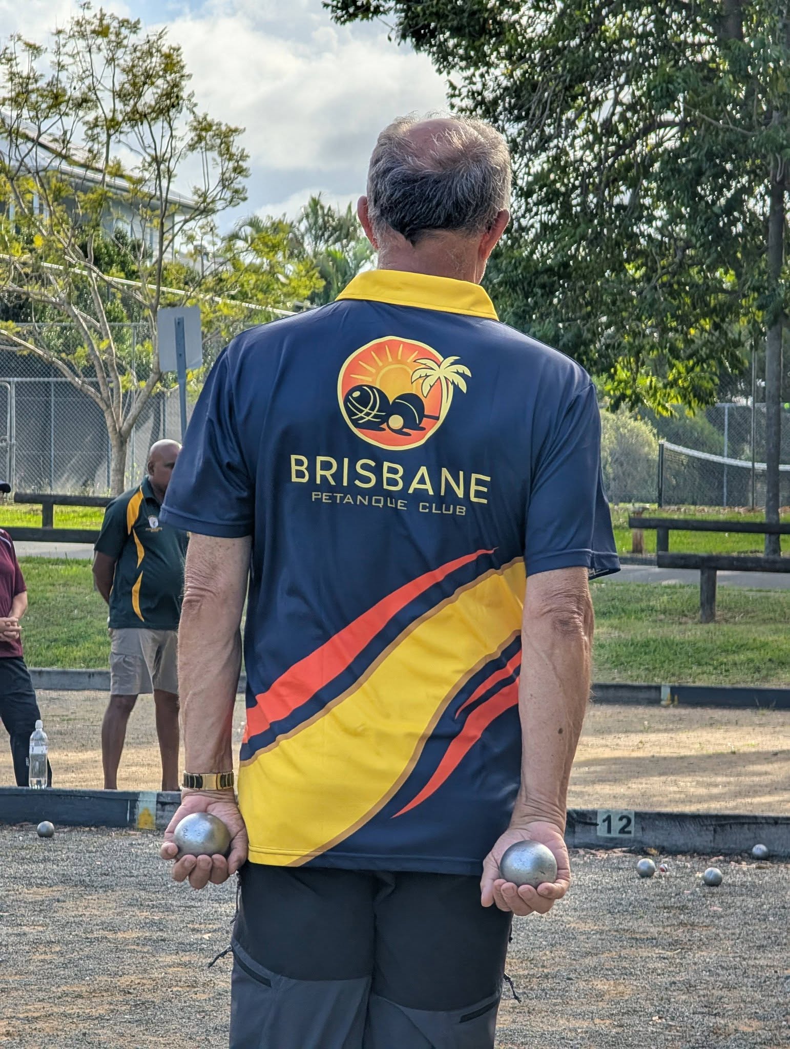 Brisbane Petanque Club member holding boules at the court